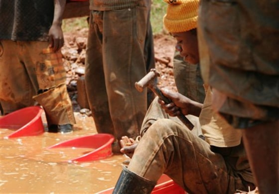 In this file photo made Sept. 26, 2005, an unidentified miner sifts through sand and smashed rocks looking for gold at the town of Mongbwalu, Congo. A new U.S. law requires companies to certify whether their products contain minerals from rebel-controlled mines in Congo and surrounding countries.